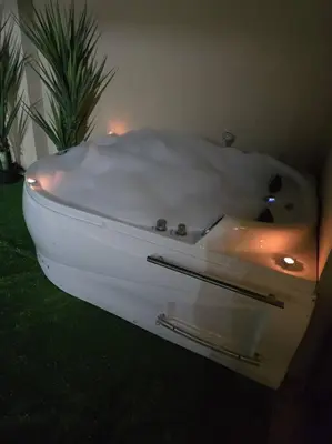 a white bath tub in a room with a plant at Jumeirah Chalet جميرا شاليه in Amman