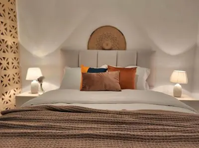 a bedroom with a large bed with orange pillows at Goga Apartment in Jabal Amman near Rainbow Street in Ash Shumaysānī