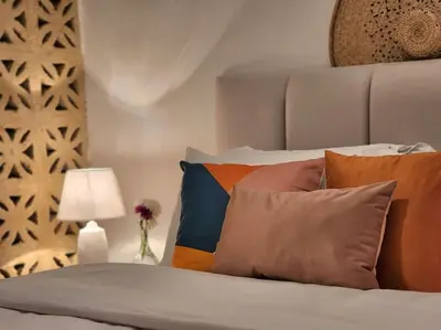 a bed with a bunch of pillows on it at Goga Apartment in Jabal Amman near Rainbow Street in Ash Shumaysānī