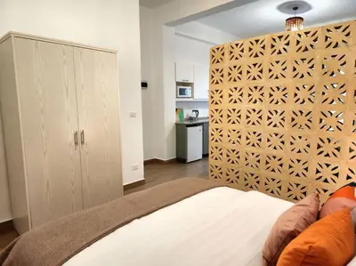 a bedroom with a bed with a wooden headboard at Goga Apartment in Jabal Amman near Rainbow Street in Ash Shumaysānī