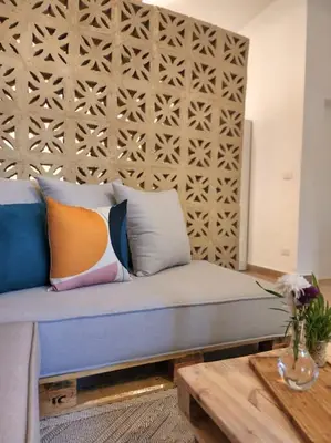 a living room with a couch with pillows and a table at Goga Apartment in Jabal Amman near Rainbow Street in Ash Shumaysānī