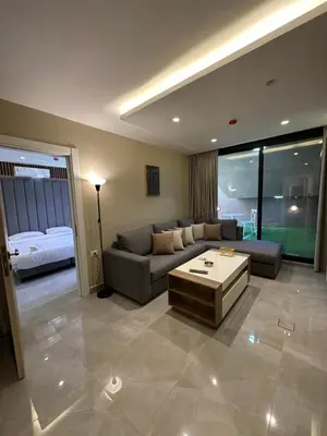 a living room with a couch and a table at Chic Apartments For Rent ave0-1 in Umm Uthainah