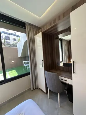 a bedroom with a desk and a window at Chic Apartments For Rent ave0-1 in Umm Uthainah