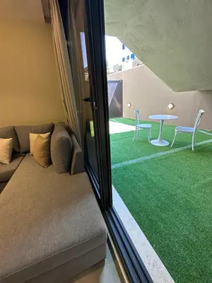 a living room with a couch and a table at Chic Apartments For Rent ave0-1 in Umm Uthainah