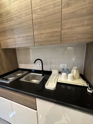 a kitchen with a sink and a counter top at Chic Apartments For Rent ave0-1 in Umm Uthainah