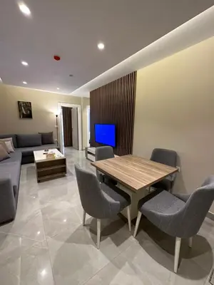 a living room with a table and chairs and a couch at Chic Apartments For Rent ave0-2 in Umm Uthainah