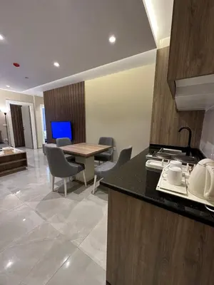 a kitchen and dining room with a table and chairs at Chic Apartments For Rent ave0-2 in Umm Uthainah