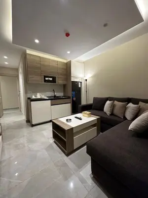 a living room with a couch and a kitchen at Chic Apartments For Rent ave0-3 in Amman