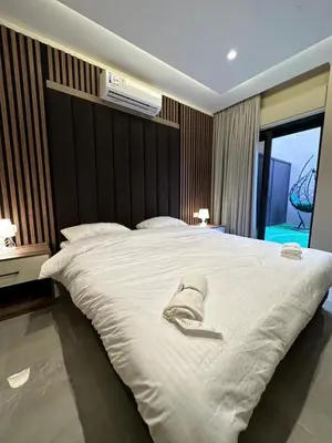 a bedroom with a large white bed with a hat on it at Chic Apartments For Rent ave0-3 in Amman