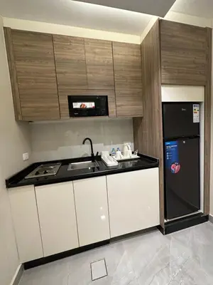 a small kitchen with a sink and a refrigerator at Chic Apartments For Rent ave0-4 in Umm Uthainah