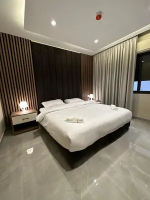 a bedroom with a large bed and two night stands at Chic Apartments For Rent ave0-5 in Amman