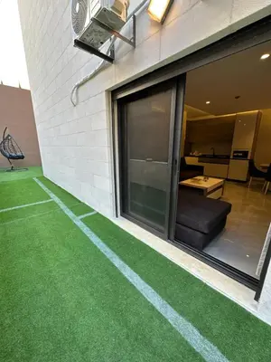 a house with a green lawn in front of a window at Chic Apartments For Rent ave0-5 in Amman