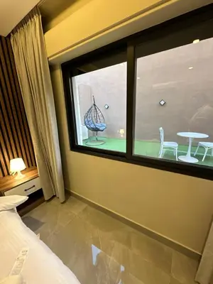 a bedroom with a window with a table and chairs at Chic Apartments For Rent ave0-5 in Amman