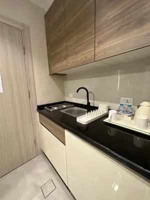 a kitchen with a sink and a black counter top at Chic Apartments For Rent ave0-7 in Umm Uthainah