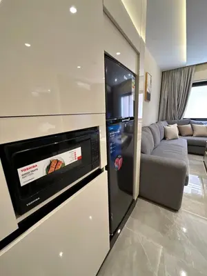a living room with a refrigerator and a couch at Chic Apartments For Rent ave0-7 in Umm Uthainah