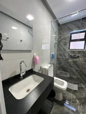 a bathroom with a sink and a shower and a toilet at Chic Apartments For Rent ave0-8 in Umm Uthainah