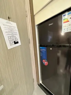 a microwave door with a sign on the wall at Chic Apartments For Rent ave0-8 in Umm Uthainah