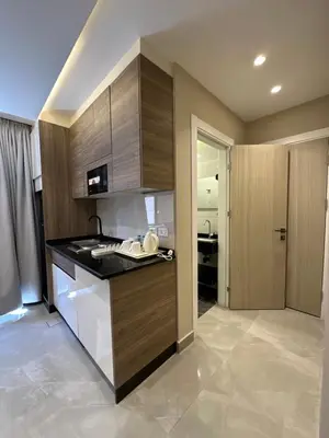 a kitchen with wooden cabinets and a counter top at Chic Apartments For Rent ave0-9 in Amman