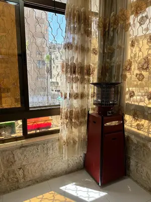 a red refrigerator in front of a window with curtains at شقة مفرشة في الرابية 3 غرف نوم in Amman