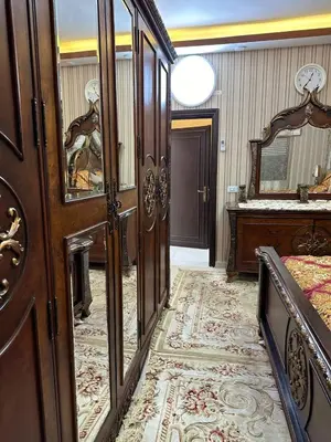 a bedroom with a bed and a mirror at شقة مفرشة في الرابية 3 غرف نوم in Amman
