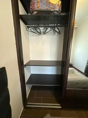 a walk in closet with a mirror and a bed at Secured Compound Hill-view Terrace in Amman