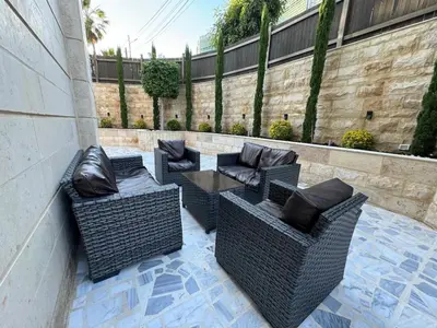 three wicker chairs and a table on a patio at 2 En-suite Rooms, Central & Garden Terrace in Amman
