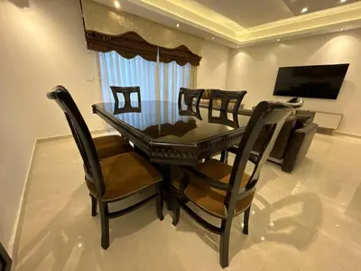 a dining room with a glass table and chairs at 2 En-suite Rooms, Central & Garden Terrace in Amman
