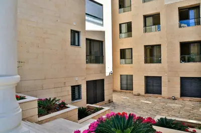 a building with black doors and flowers in front of it at 2 En-suite Rooms, Central & Garden Terrace in Amman