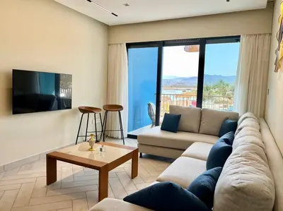 a living room with a couch and a table at Luxury Apt with Private Beach In Ayla in Aqaba