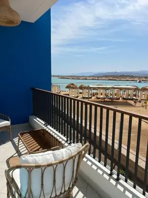 a balcony with a chair and a view of the beach at Luxury Apt with Private Beach In Ayla in Aqaba