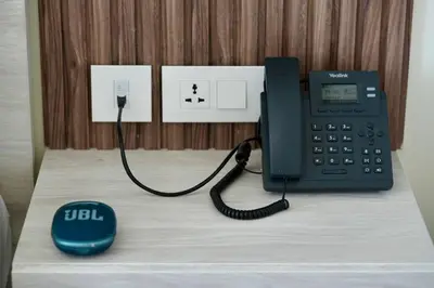 a black phone and a mouse on a desk at Luxury Apt with Private Beach In Ayla in Aqaba