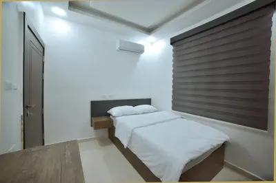 a bedroom with two beds and a wooden wall at رمّ للأجنحة Rum Royal Suites in Irbid