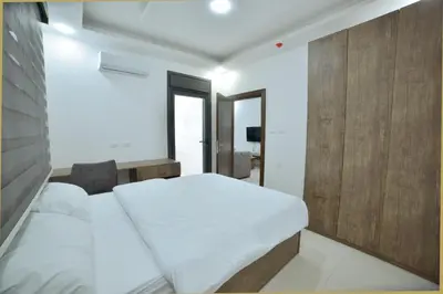a bedroom with a white bed and a wooden wall at رمّ للأجنحة Rum Royal Suites in Irbid