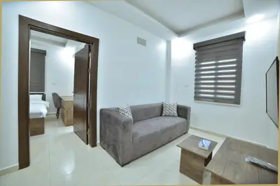 a living room with a couch and a table at رمّ للأجنحة Rum Royal Suites in Irbid