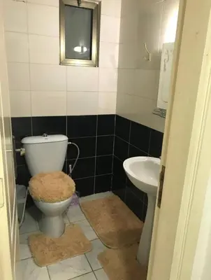 a bathroom with a toilet and a sink at شقةارضية فاخرة مفروشة عمان ضاحية الرشيد in Ţāb Kirā‘