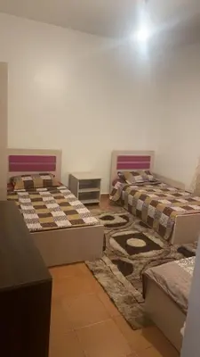 two beds in a room with a rug at شقةارضية فاخرة مفروشة عمان ضاحية الرشيد in Ţāb Kirā‘
