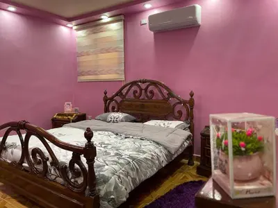 a bedroom with a bed and a purple wall at Luxury Duplex In the center of Irbid -Spacious 4BR in Irbid