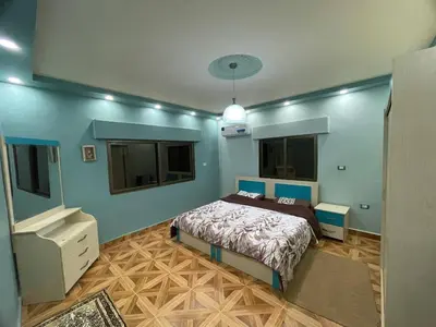 a bedroom with a bed and two windows at Luxury Duplex In the center of Irbid -Spacious 4BR in Irbid