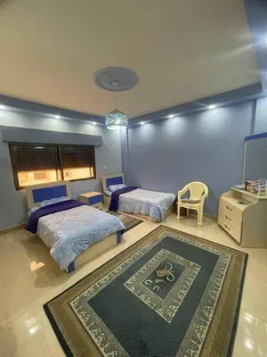 a bedroom with two beds and a rug at Luxury Duplex In the center of Irbid -Spacious 4BR in Irbid
