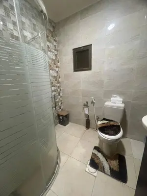 a bathroom with a toilet and a glass shower at Luxury Duplex In the center of Irbid -Spacious 4BR in Irbid