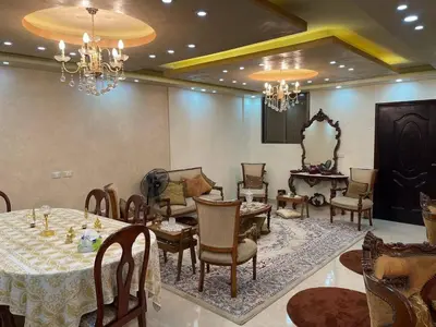 a dining room with a table and chairs and chandeliers at Luxury Duplex In the center of Irbid -Spacious 4BR in Irbid