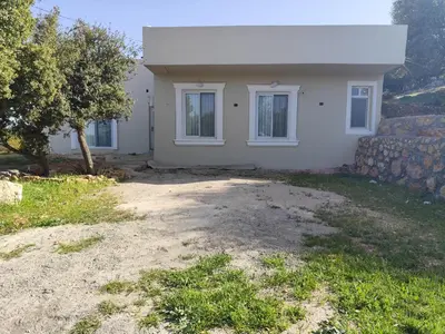 a white house with two windows and a yard at فيلا بيت الجبل in Ishtafaynā