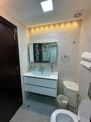 a bathroom with a sink and a toilet and a mirror at The Roof Top Lounge in Umm Uthainah