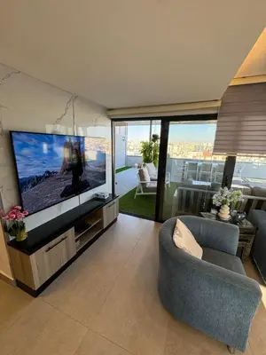 a living room with a large flat screen tv at The Roof Top Lounge in Umm Uthainah