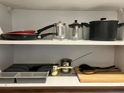 a kitchen shelf with pots and pans on it at Cozy & Comfortable Studio in the heart of Amman, Studio #17 in Umm Uthainah