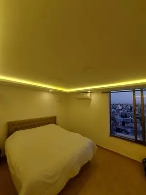 a bedroom with a white bed and a window at The view IVI in Umm Uthainah