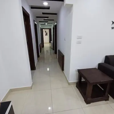 a hallway with a couch and a table in a building at Laperla family apartment 1 in Al Yādūdah