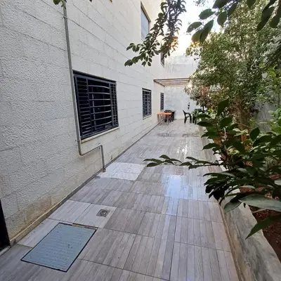 a courtyard with a table and chairs in a building at Laperla family apartment 1 in Al Yādūdah