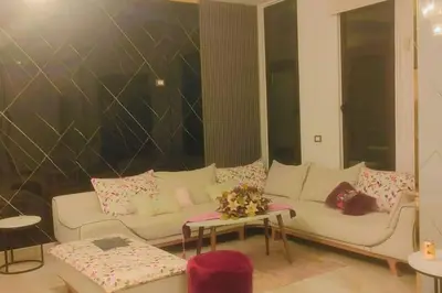 a living room with a white couch and pink pillows at villa rose3 in Mūbiş