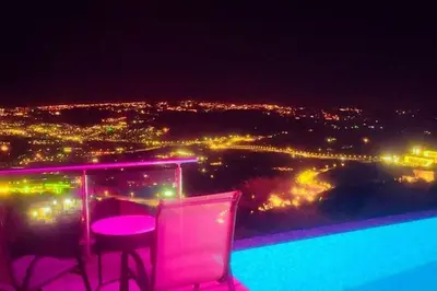 a view of a city at night with a table and chairs at villa rose3 in Mūbiş